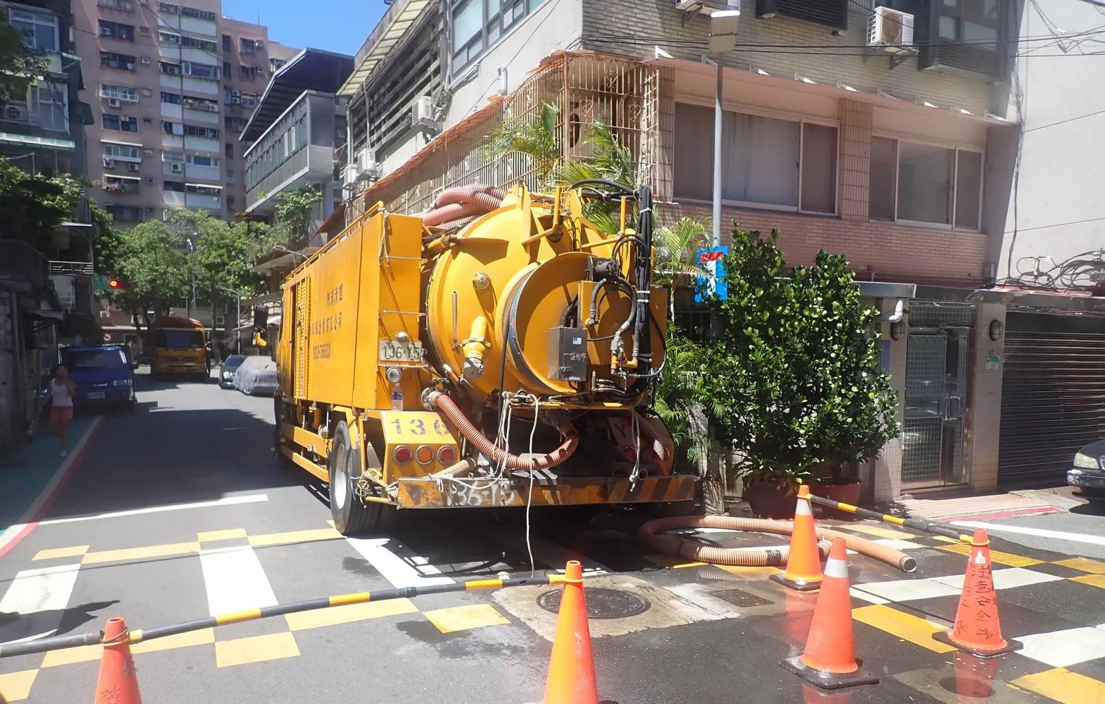 黃色清溝車停在巷內,旁邊擺著三角錐
